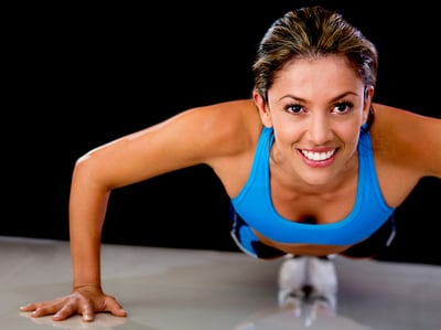 Determined fit woman exercising by doing push-ups