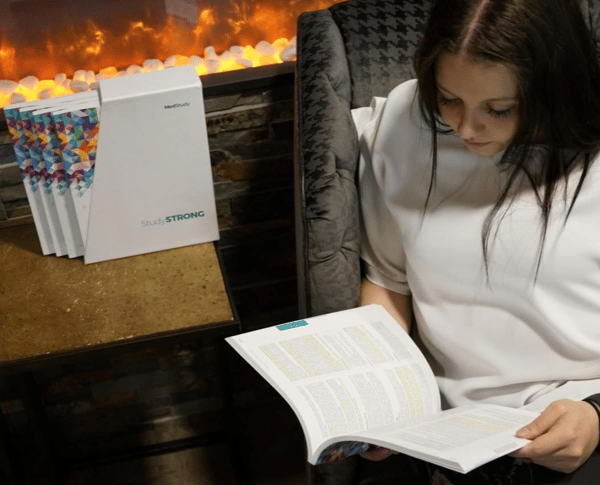 Woman reading new material from the Core next to a fire place