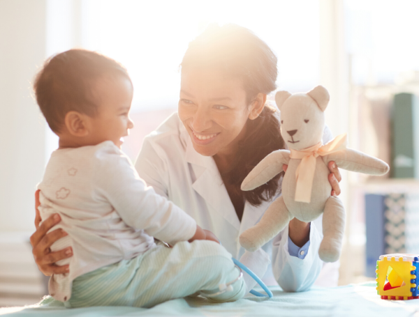 doctor holding up a stuffed animal for a child patient, physician burnout prevention