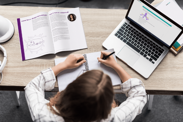 Core Computer and book on a desk with a female medical student studying How to Become a Rheumatologist